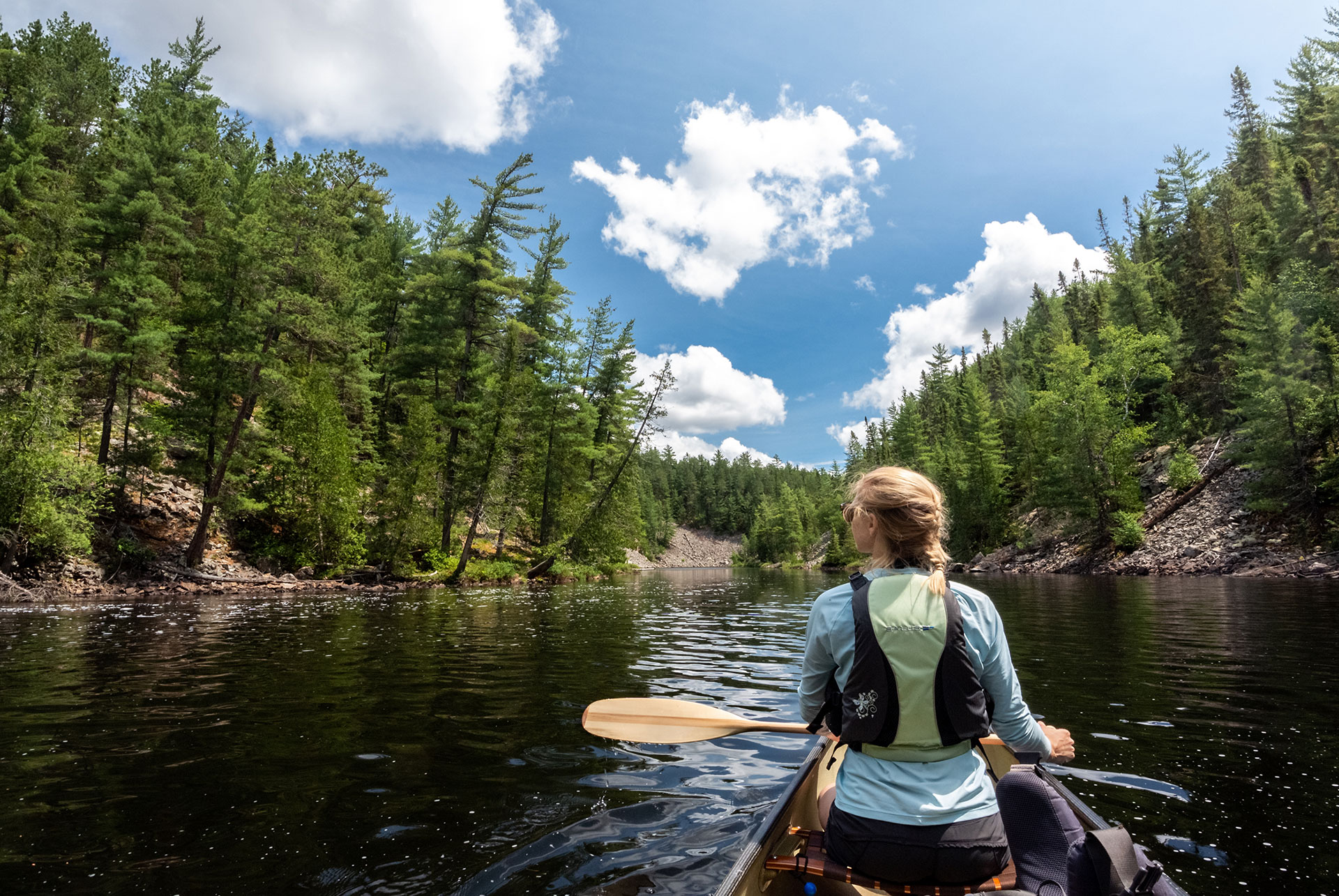 woman paddles a canoe on the Evelyn River