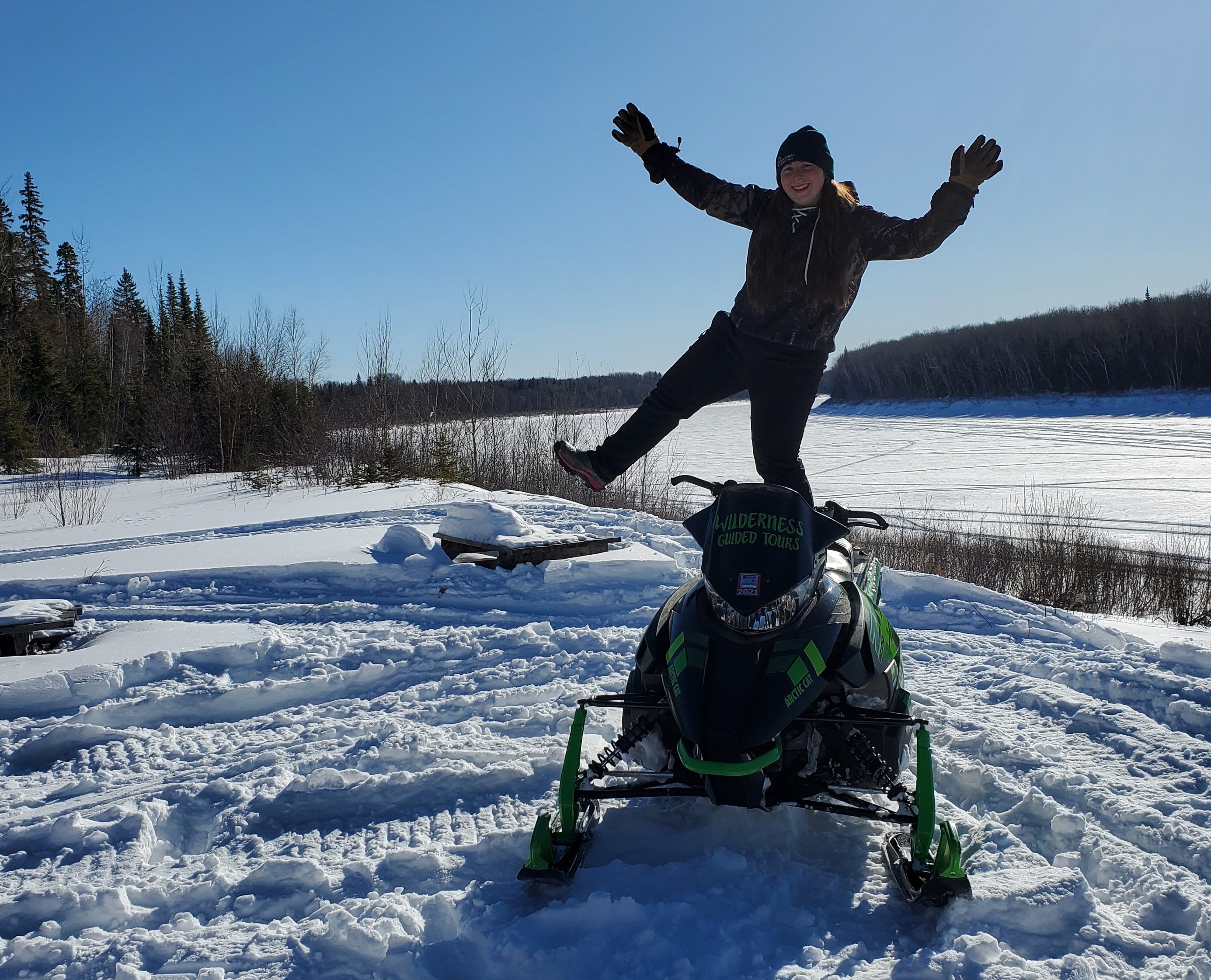 Mylène se tient debout sur une motoneige. 
