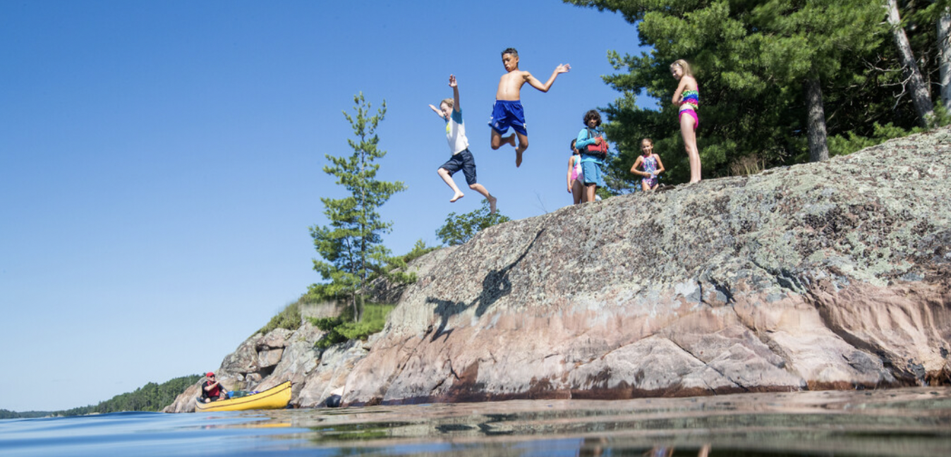 Kids jumping into French River Colin Field