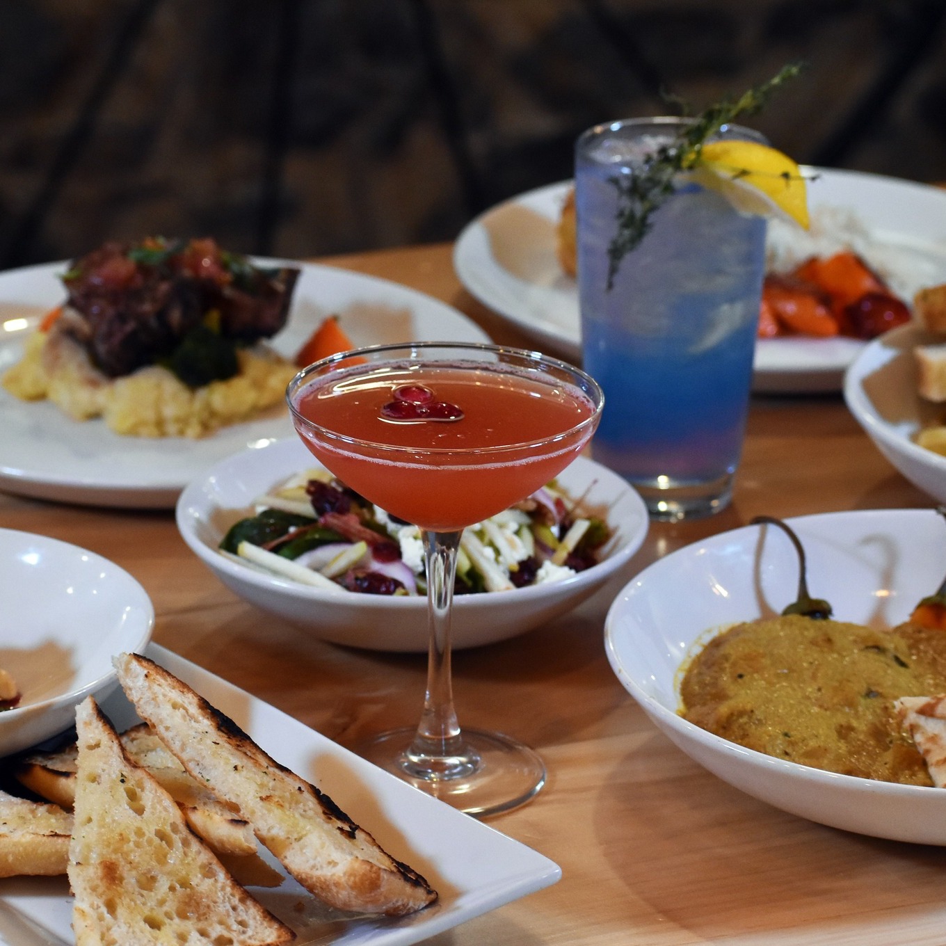 a table filled with various delicious entrees and colourful cocktails at Block Public House in North Bay.