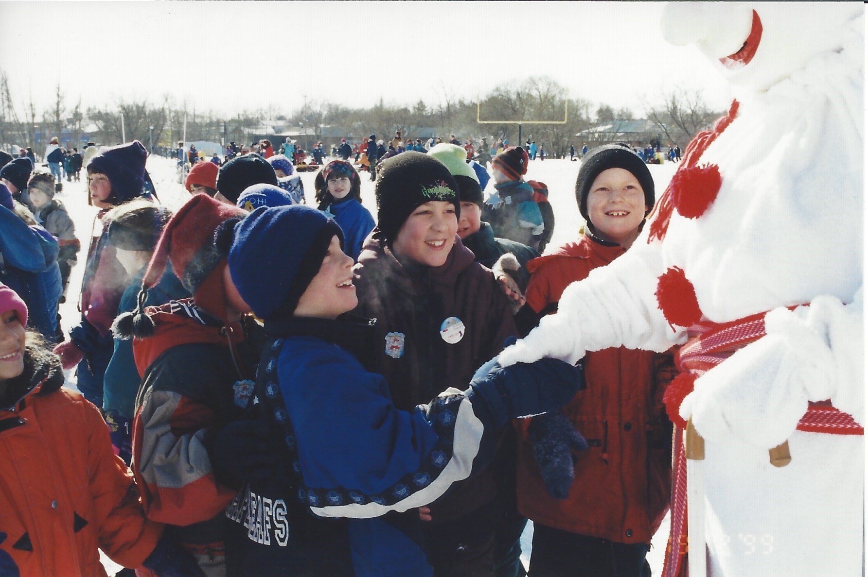 Le Bonhomme salue des élèves, dans une cour d'école, en 1999.