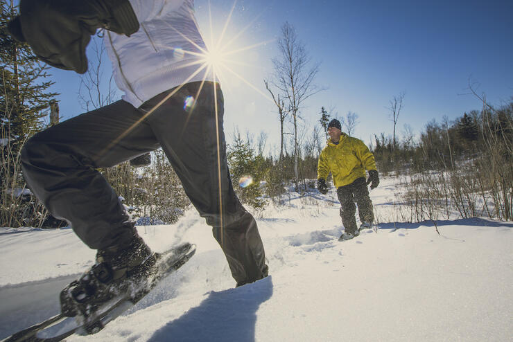 Man and woman snowshoeing on a sunny day 