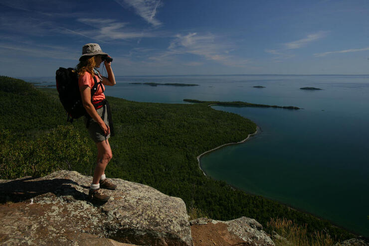 Woman looking through binoculars at top of lookout