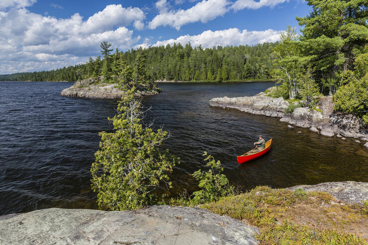 Solo canoeist paddling on beautiful lake.