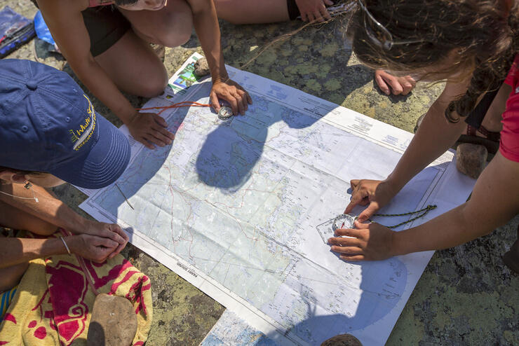 Group of people looking a topo map on a rock